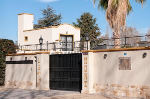 Las CompuertasLa Moni的一座白色的房子,有黑色的大门和棕榈树
