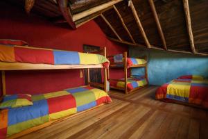 MachachiMAUCA PEDREGAL的红色墙壁的客房内设有两张双层床。