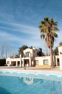 Las CompuertasLa Moni的棕榈树和游泳池的房子