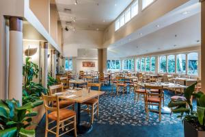 基督城公园酒庄基督城希尔顿逸林酒店的餐厅设有桌椅和窗户。