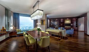 岘港Hilton Da Nang的用餐室以及带桌椅的起居室。