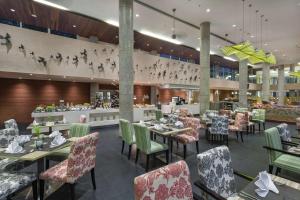 库塔巴厘岛机场希尔顿花园酒店的餐厅内带桌椅的用餐室