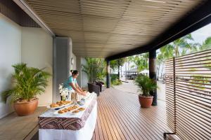 南迪希尔顿斐济酒店 - 索奈萨利岛的站在甲板上带餐桌的女人