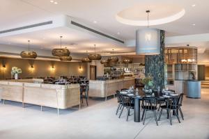 奥克兰Doubletree By Hilton Karaka的一间带桌椅的餐厅和一间酒吧