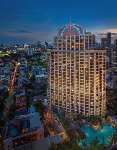 曼谷曼谷康莱德酒店的一座高大的建筑,上面有标志