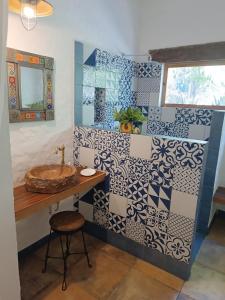 坎昆Jungle Lodge CANCUN AEROPUERTO的浴室铺有蓝色和白色瓷砖,配有水槽