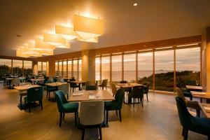 本部Hilton Club The Beach Resort Sesoko的餐厅设有桌椅和大窗户。