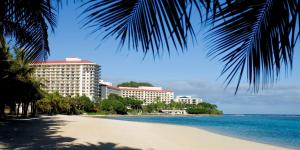 塔穆宁关岛希尔顿spa度假酒店的享有海滩、建筑和大海的景色