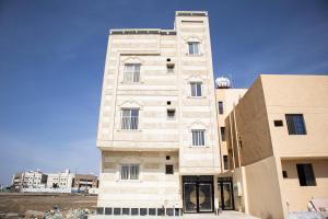 AR RummanahLuxurious Family Apartments 15Mins Drive to Al-Masjid Nabawi - Qaswarah residence的前面有一扇门的高楼