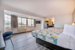 滨海城蒙特利6号汽车旅馆 - 滨海城的酒店客房设有一张床、一张书桌和窗户。