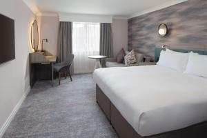 巴斯DoubleTree by Hilton Bath的酒店客房设有一张大床和一张书桌。