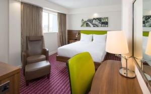 伯明翰希尔顿伯明翰珠宝区汉普顿酒店的酒店客房配有一张床、一张桌子和一把椅子。