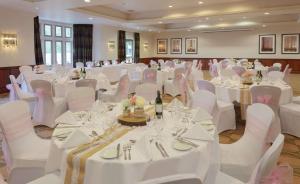 埃文河畔斯特拉特福英国埃文河畔斯特拉特福希尔顿逸林酒店的宴会厅配有白色的桌子和白色的椅子