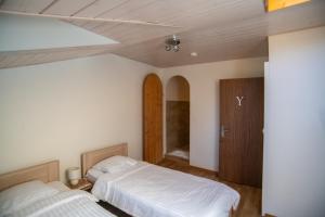MiesAuberge de La Couronne的一间卧室设有两张床和木制天花板