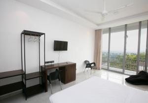 康提The Cloud Hanthana, Kandy的一间卧室配有一张床、一张书桌和一个窗户。