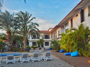 El YaquePOSADA RANCHO DELFIN的一个带椅子的度假村,一个游泳池和棕榈树