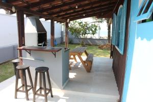 伊塔波阿Casa das Ondas的庭院设有酒吧和野餐桌。