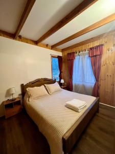 拉斯特朗卡斯Cabañas Bosque las Trancas的一间卧室配有一张床,上面有两条毛巾