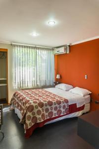 塔尔卡Hotel Stella Talca的一间卧室配有一张带橙色墙壁的大床