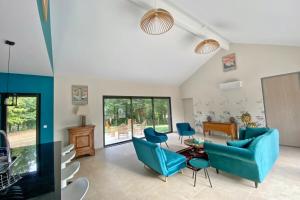 PanazolLe Cottage proche du Golf的客厅配有蓝色的沙发和椅子