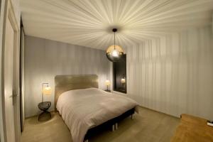 PanazolLe Cottage proche du Golf的一间卧室配有一张大床和一个吊灯。