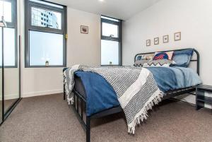 墨尔本2 Bed Apt with CAR Parking in SouthYarra（TF150221）的一间卧室配有一张带蓝色棉被的床和窗户。