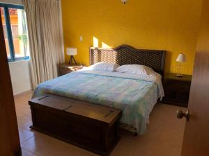 TucacasCasa en Caribbean con Wifi的一间卧室设有一张床和黄色的墙壁