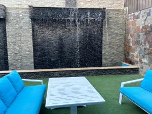 Sheikh ZayedTrio villa with falls in compound فلا بحديقة كبيره وشلالات صناعية的喷泉设有2把蓝色的椅子和桌子