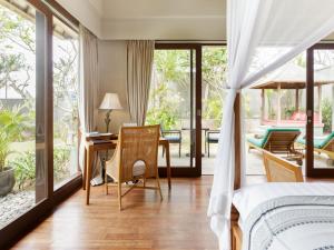 努沙杜瓦The Shanti Residence by Elite Havens的卧室配有一张床和一张桌子及椅子