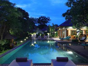 努沙杜瓦The Shanti Residence by Elite Havens的夜间在度假村的游泳池