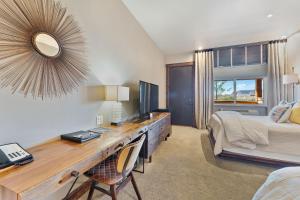布拉夫沙漠玫瑰小屋度假酒店的一间卧室配有书桌、一张床和镜子