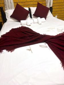 Caloundra WestCosy holiday entire unit 1的一张带白色床单和勃 ⁇ 第枕头的床
