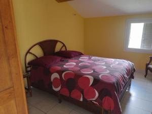 卡拉库恰Maison de caractère au coeur de la corse rurale的一间卧室配有一张带红白毯子的床