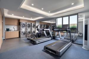 深圳深圳罗湖东门君亭尚品酒店的健身房设有跑步机、椭圆机和洗衣机
