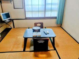 富士市Taiya Ryokan的小房间设有桌子和电视