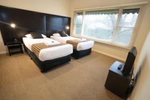 巴拉腊特君主公园汽车旅馆的酒店客房设有两张床和电视。