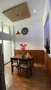 北榄府The Loft Living Space的一间设有桌子和墙上时钟的餐厅