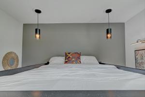 休斯顿Victoria Island Palace Toyota Center Downtown Houston的卧室配有一张带两个灯的大白色床