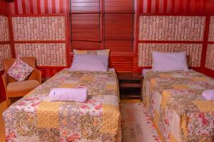 南迪Tahals Holiday Villas的一间设有两张床和椅子的房间