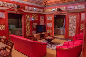 南迪Tahals Holiday Villas的客厅配有红色家具和电视