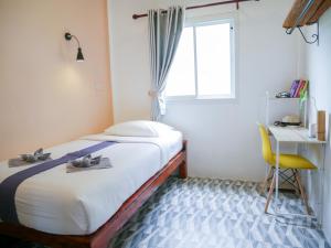 高兰Enda Lanta Bungalows的一间卧室配有一张床、一张书桌和一个窗户。
