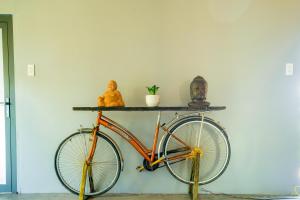Cái RăngAnn Village的一辆橘色自行车停在墙上,墙上挂着雕像