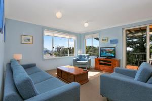 霍克斯内斯特Aquarius Apartment 7的客厅配有2张蓝色沙发和电视