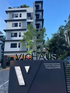 新加坡VicHaus Serviced Apartment的前面有标志的高大的白色建筑