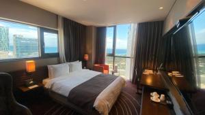 釜山路易斯汉密尔顿百斯特酒店海云台的酒店客房设有一张床和大窗户