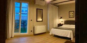 卡索拉塔尔西斯酒店的一间卧室设有一张床和一个大窗户