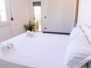 斯培西亚The view的白色卧室,床上配有白色的床单和毛巾
