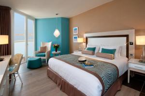 恩波其克Herods Dead Sea – A Premium Collection by Fattal Hotels的酒店客房带一张大床和一把椅子