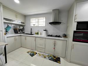 阿罗士打ORKED HOMESTAY的厨房配有白色橱柜和瓷砖地板。