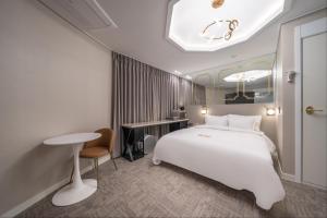 仁川市DK Incheon airport hotel的酒店客房配有一张床铺、一张桌子和一张书桌。